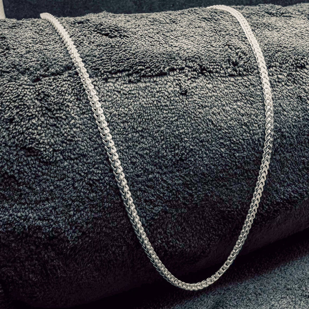 Gray textured rug with a white rope border on a dark gray background