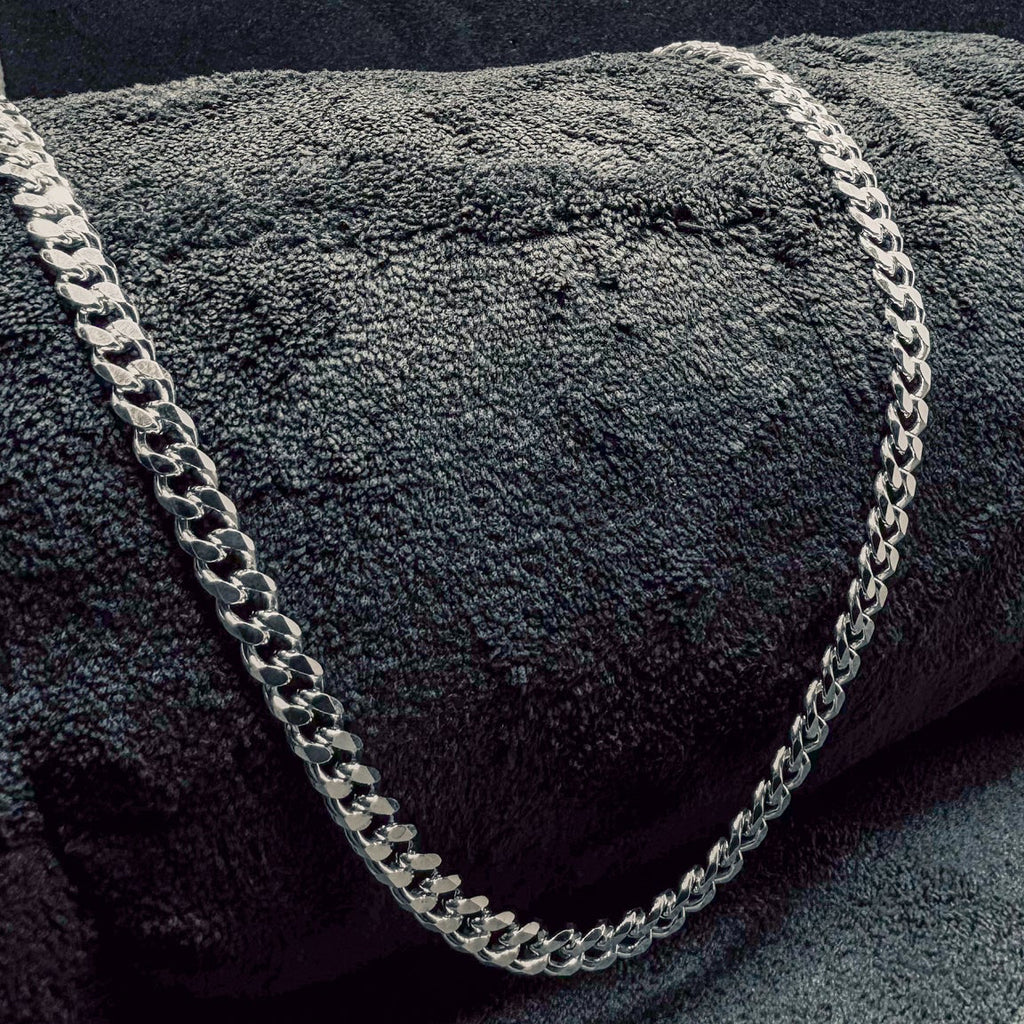 Silver chain on a textured dark surface