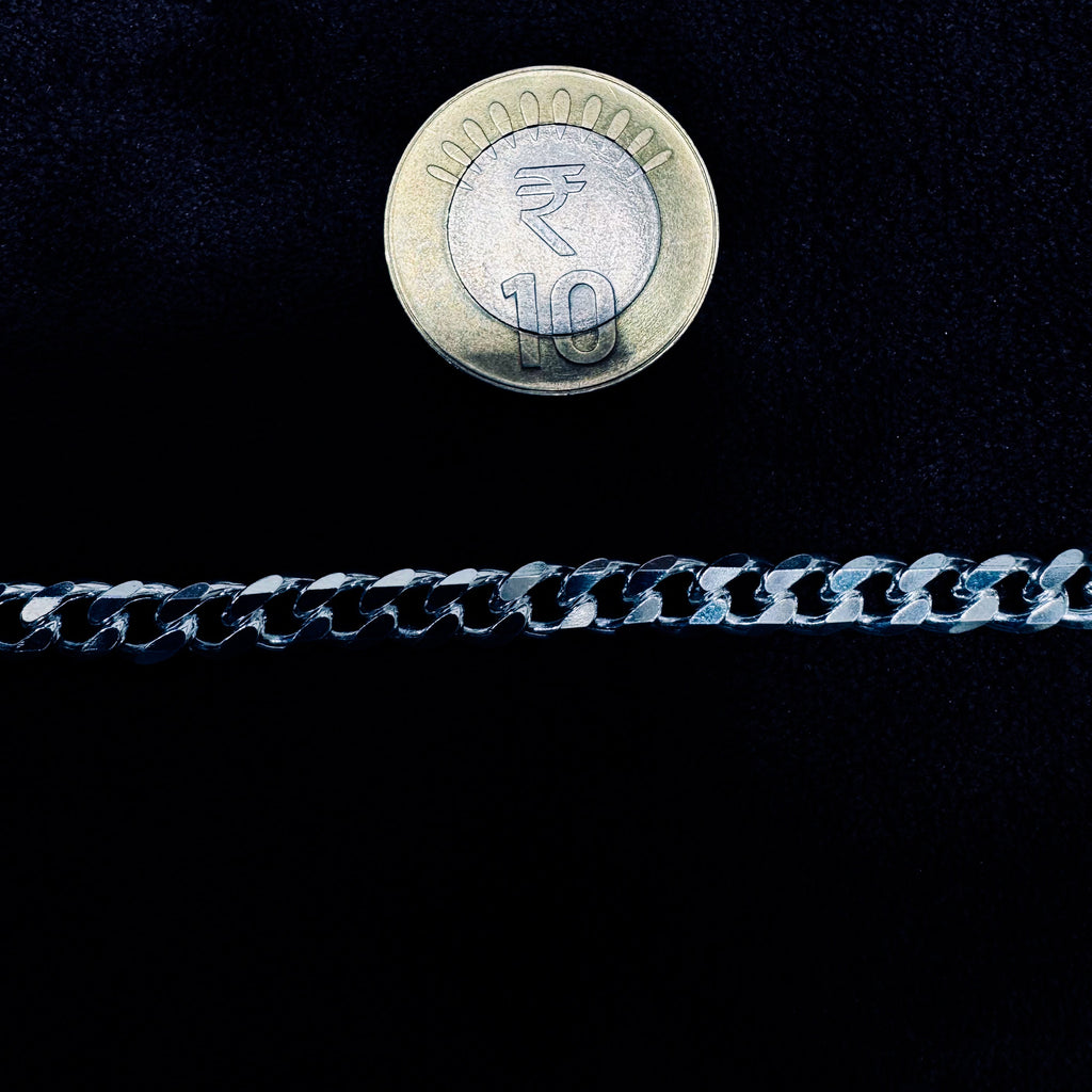 Ten rupee coin on a chain against a black background